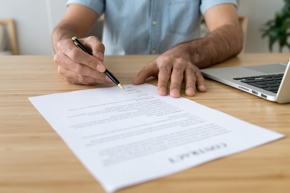 Overseas buyer signing a property purchase contract in Ghana, representing the legal and financial steps involved in buying property in Ghana.